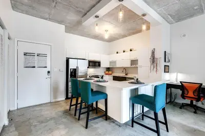a kitchen with a white counter and blue chairs at Super convenient 1br apartment in Downtown 4 p 1708 in Miami