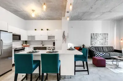 a kitchen with a large white island with green chairs at Super convenient 1br apartment in Downtown 4 p 1708 in Miami