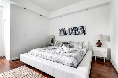 a white bed with a teddy bear sitting on it at Stylish 2br Apt in Downtown City View 3208 in Miami