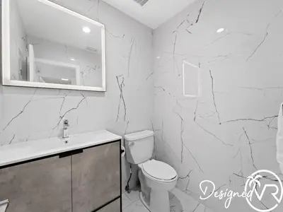 a bathroom with a toilet and a marble wall at Villa wpool spa game room in Hollywood