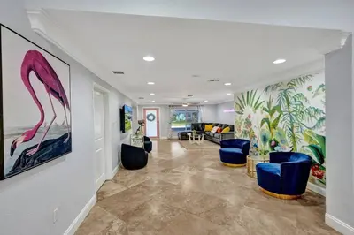 a lobby with blue chairs and a painting on the wall at Hot Tub! Roof Top! Firepit! Boat Dock! in Fort Lauderdale