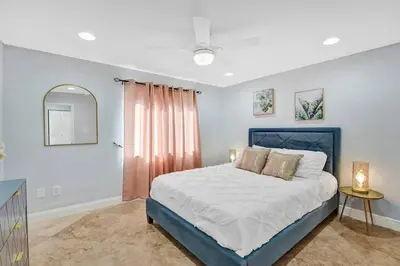 a bedroom with a bed with a blue frame and a window at Hot Tub! Roof Top! Firepit! Boat Dock! in Fort Lauderdale