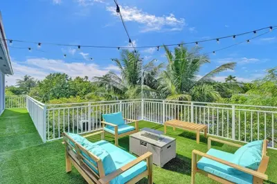 a patio with chairs and a table on a balcony at Hot Tub! Roof Top! Firepit! Boat Dock! in Fort Lauderdale