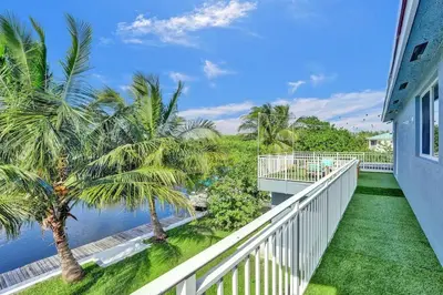 a balcony with palm trees and the water at Hot Tub! Roof Top! Firepit! Boat Dock! in Fort Lauderdale