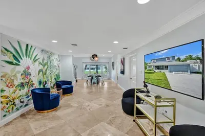 a living room with a large painting on the wall at Hot Tub! Roof Top! Firepit! Boat Dock! in Fort Lauderdale