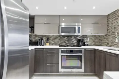 a kitchen with a stainless steel oven and microwave at The Grand Wonder in Miami