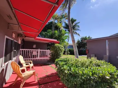 a porch with two chairs and a house at Wonderful Studio Cottage 2 people V5 in Miami