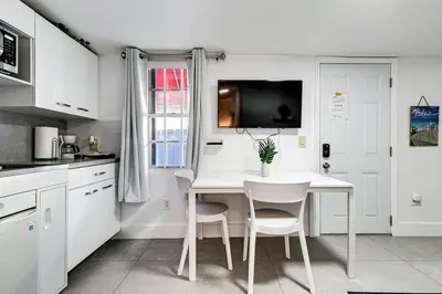 a white kitchen with a white table and chairs at Swinging London Studio 3 people V6 in Miami