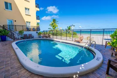 a swimming pool on a patio next to a building at Beach Front 1 Bedroom with Ocean View, Pool and Parking in Hollywood