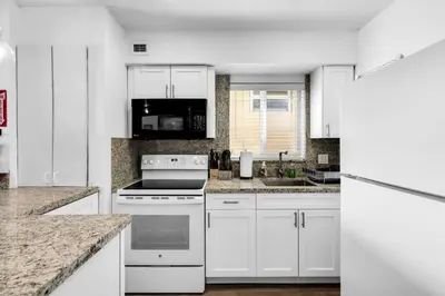 a kitchen with white cabinets and a stove top oven at Beach Front 1 Bedroom with Ocean View, Pool and Parking in Hollywood