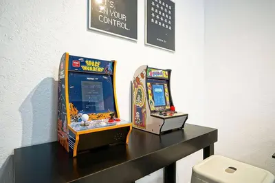 two arcade games sitting on top of a table at Wynwood Bungalow Hottub & Pking in Miami