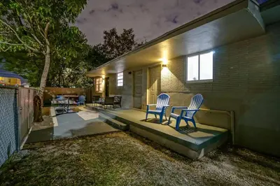 two chairs sitting on the patio of a house at night at Wynwood Bungalow Hottub & Pking in Miami