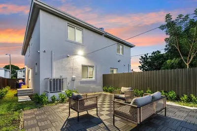 a white house with two chairs and a fence at 4 Bedroom Holiday Retreat BBQ Marketplace in Miami