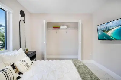 a bedroom with a bed and a tv on a wall at 4 Bedroom Holiday Retreat BBQ Marketplace in Miami