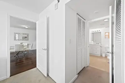 a room with white walls and a kitchen with a table at Well Located Unit with parking - Heart Of Brickell in Miami
