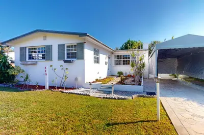 a white house with a tent in the yard at Hallandale Hideaway in Hallandale Beach