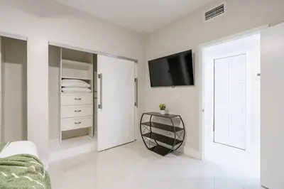 a white living room with a tv and a bed at New Miami & Calle Ocho Home with Arcade! in Miami
