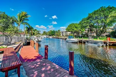 a river with boats docked next to a dock at Citrus Isles Waterfront Home in Fort Lauderdale