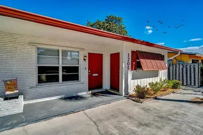 a house with a red door on a street at Citrus Isles Waterfront Home in Fort Lauderdale