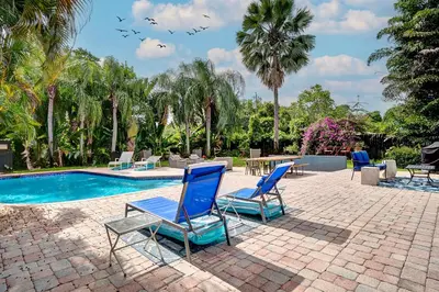 a group of blue chairs sitting next to a swimming pool at Breathtaking Pool Home and Backyard by Wilton Mnrs in Fort Lauderdale