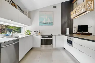 a white kitchen with a sink and a window at Breathtaking Pool Home and Backyard by Wilton Mnrs in Fort Lauderdale