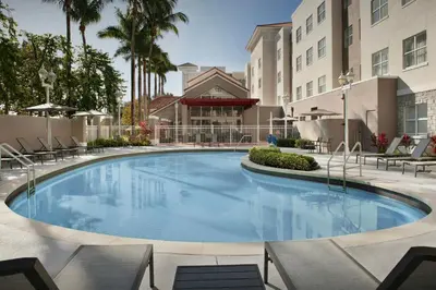 a large swimming pool with chairs and a building at Residence Inn by Marriott Fort Lauderdale Airport & Cruise Port in Dania Beach