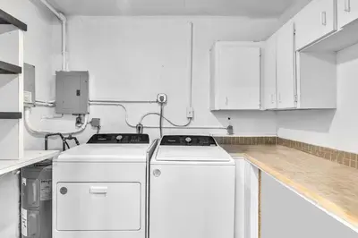 a kitchen with white cabinets and a washer and dryer at 3 Bedroom Villa In F Lauderdale Casino & Beach in Fort Lauderdale