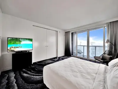a hotel room with a bed and a flat screen tv at WVR Vacation Residences 602 in Fort Lauderdale