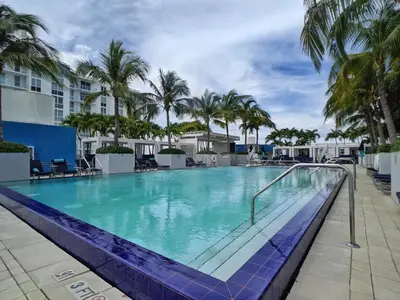 a large swimming pool with palm trees in a resort at WVR Vacation Residences 602 in Fort Lauderdale