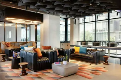 a lobby with leather couches and tables and windows at Moxy Miami Wynwood in Miami