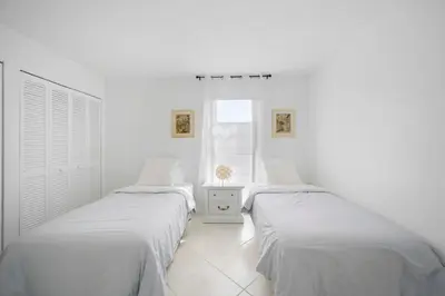 two beds in a room with white walls and a window at Le Cartier Sunny Isles Ocean Paradise in Sunny Isles Beach