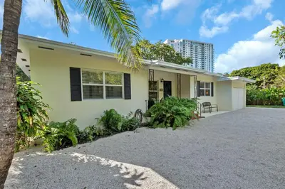 a house with a palm tree in front of it at Casa Linda Gated 3 bed 2 bath by the River 1810 in Miami