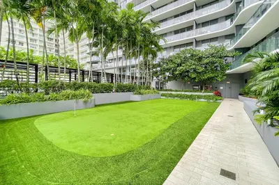 a courtyard in a building with a green lawn at Unwind in Your Amazing City View Apartment in Miami