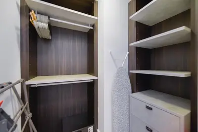 a walk in closet with wooden shelves and a drawer at Unwind in Your Amazing City View Apartment in Miami