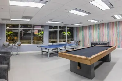 two ping pong tables in a room with windows at Miami Brickell 3 Bedrooms high ceiling loft in Miami