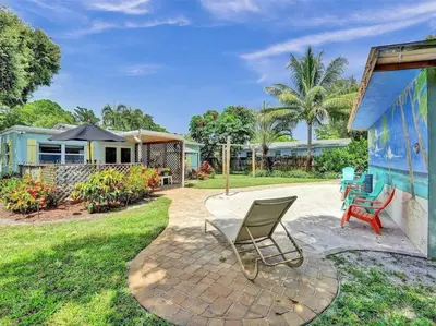 a patio with a chair and a house at Tropical Oasis - BBQ and Beach-Inspired Nook in Fort Lauderdale