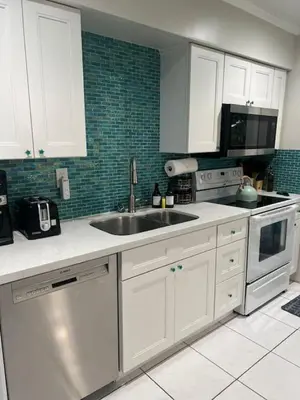 a kitchen with white cabinets and a sink at Tropical Oasis - BBQ and Beach-Inspired Nook in Fort Lauderdale