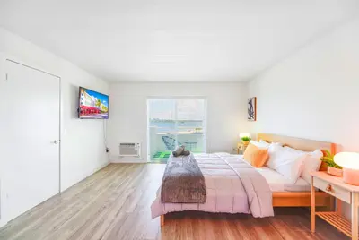 a white bedroom with a bed and a window at Front Bay & Unique Stay for a Relaxing Experience in Miami Beach