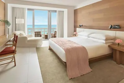 a hotel room with a bed and a living room at The Miami Beach EDITION in Miami Beach