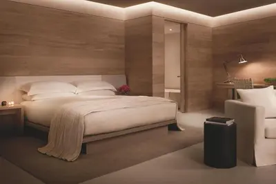 a bedroom with a large white bed and a chair at The Miami Beach EDITION in Miami Beach