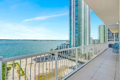 a balcony with a view of the ocean and a building at Brickell Oasis 5BR Free Parking Pool Gym and More in Miami