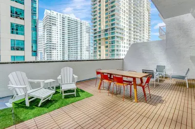 a balcony with a table and chairs and buildings at Brickell Oasis 5BR Free Parking Pool Gym and More in Miami