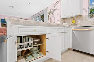 a kitchen with white cabinets and a sink at The Betty A Glam Getaway in Fort Lauderdale in Fort Lauderdale