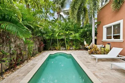 a swimming pool in the middle of a yard with trees at The Betty A Glam Getaway in Fort Lauderdale in Fort Lauderdale