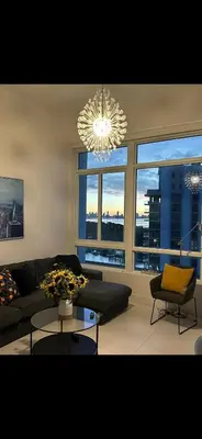 a living room with a couch and a chandelier at Castle Ph11 Penthouse with Balcony, Free Parking, Pool, Tennis, Beach Access in Miami Beach