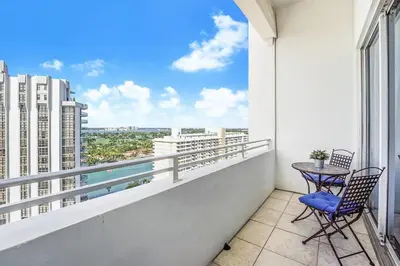 a balcony with two chairs and a table at Castle Ph11 Penthouse with Balcony, Free Parking, Pool, Tennis, Beach Access in Miami Beach