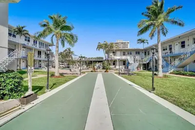 a street in front of a building with palm trees at Vistamar Waterfront Beach Abode -Walk to the Beach in Fort Lauderdale