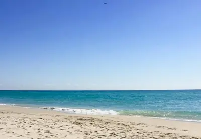 a sandy beach with the ocean in the background at Beachside Bliss: 1BR Retreat Amenities in Sunny Isles Beach