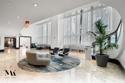 a large lobby with chairs and a table and plants at FontaineBleau Resort Balcony w Ocean + Bay View in Miami Beach