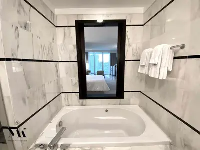 a bathroom with a bath tub and a mirror at FontaineBleau Resort Balcony w Ocean + Bay View in Miami Beach